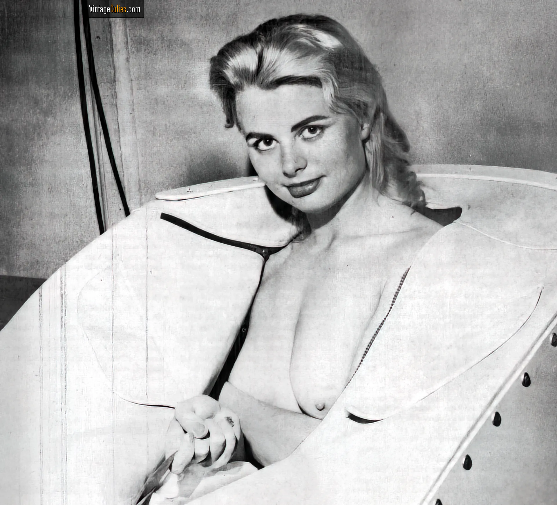 Burlesque blonde with pouted lips shows her naked tits