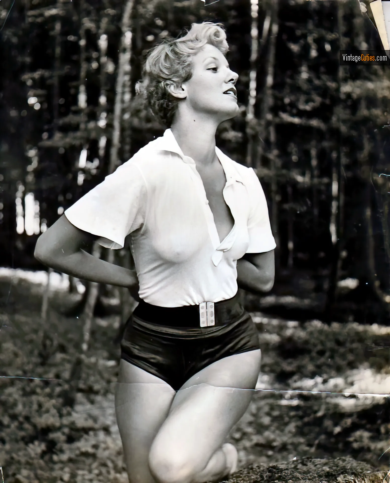 Curvy burlesque blonde in shorts and a transparent white shirt