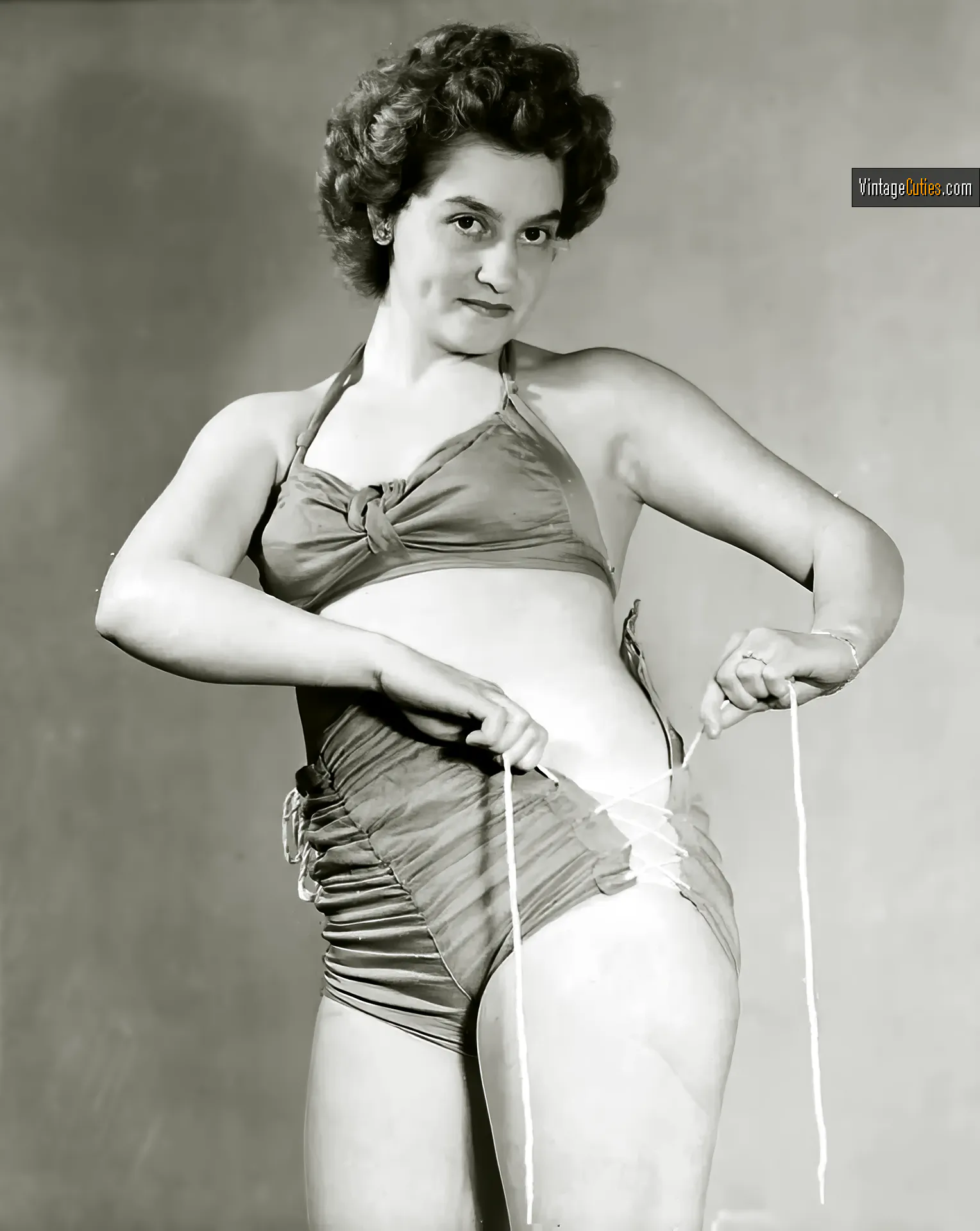 Older burlesque lady with curves tries to tie her bikini