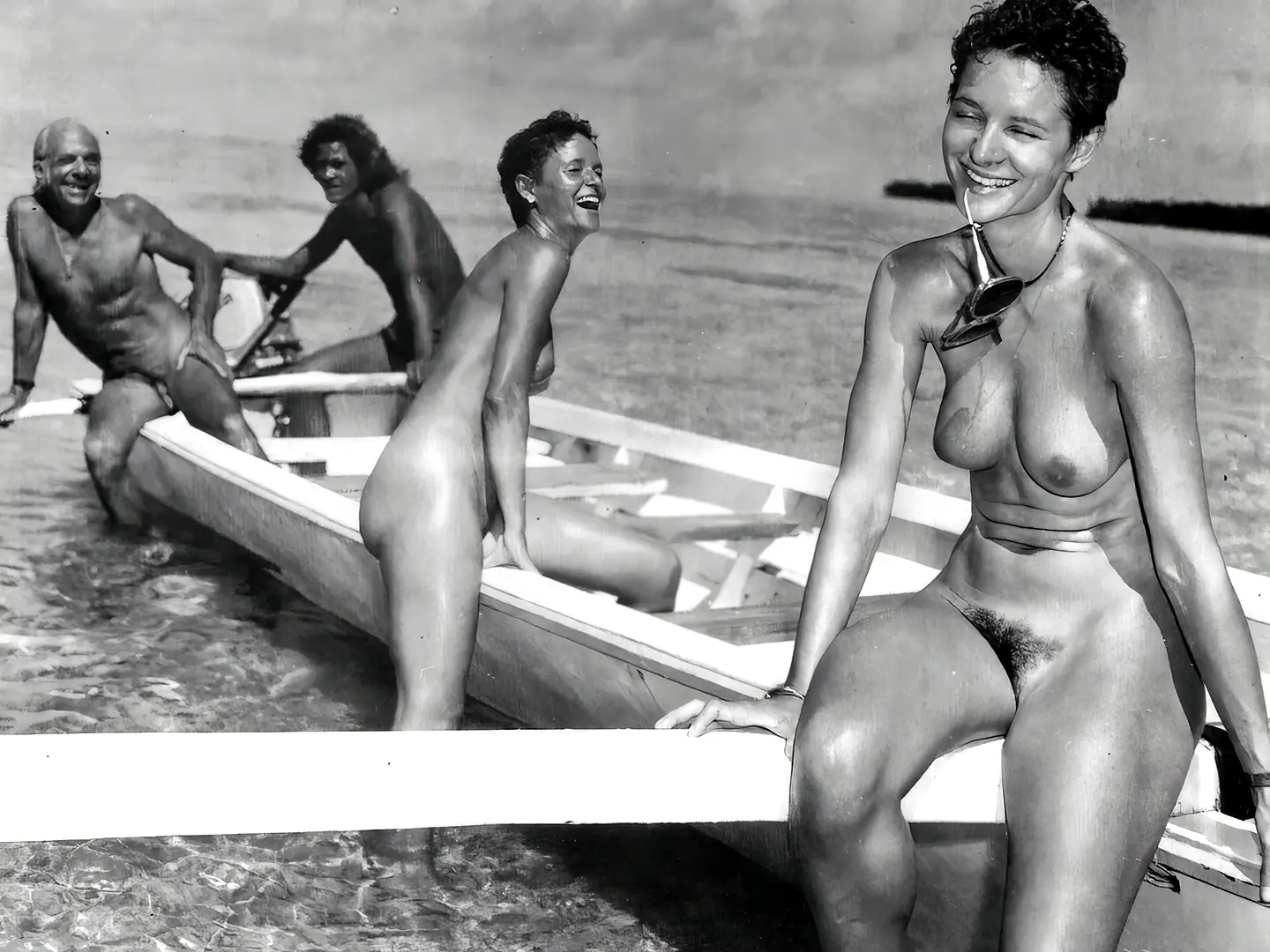 Vintage nudist porn videos with nudist family of 2 naked women and 2 mature men sitting in a boat on the seashore